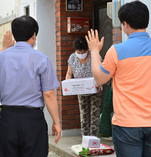 18일 오후 대구 남구 봉덕동의 한 주택 앞에서 메르스 영향으로 자가 격리된 의심환자의 부인이 쌀과 라면, 통조림 등을 내려놓고 가는 공무원들을 향해 감사의 인사를 하고 있다. 정운철 기자 woon@msnet.co.kr