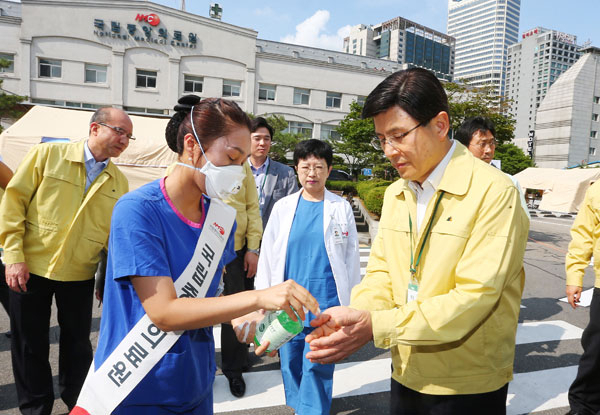 황교안 신임 국무총리가 18일 오후 서울 을지로 중동호흡기증후군(메르스) 중점병원인 국립중앙의료원에서 치료시설을 점검하고 의료진을 격려한 뒤 떠나기 전 손을 소독하고 있다. 연합뉴스