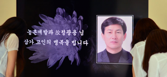 중국 지린성 지안에서 발생한 버스추락 사고로 숨진 정광용 경북도 사무관의 추모영상이 2일 오후 경북도청 1층 로비에 설치됐다. 이날 동료직원들이 고개를 숙이며 애도를 표하고 있다. 정운철 기자 woon@msnet.co.kr