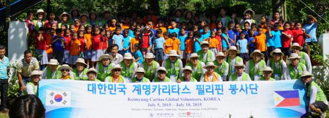 계명카리타스 봉사단원들이 지난 13일 필리핀 말라보초등학교 신축 교실 앞에서 준공기념 촬영을 했다, 오른쪽 부분이 새로 지은 교실이다. 계명카리타스 봉사단 제공