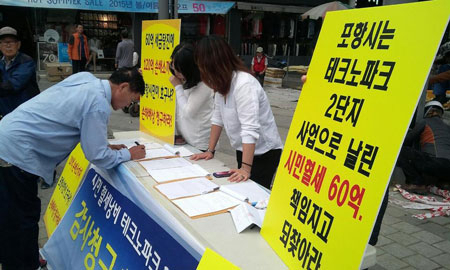 참여예산네트워크 회원들이 지난 17일 죽도시장에서 시민들을 상대로 주민감사 청구를 위한 서명을 받고 있다. 참여예산네트워크 제공