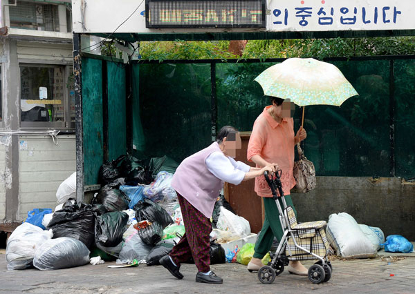 30일 오전 대구 서문시장 5지구에 위치한 쓰레기장 앞으로 시민들이 지나고 있다. 이 쓰레기장에는 생활 쓰레기와 음식물 쓰레기가 뒤섞여 악취를 풍겨 주변 상인들의 원성을 사고 있다. 김영진 기자 kyjmaeil@msnet.co.kr