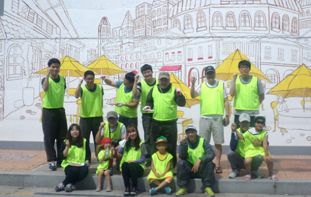 OCI머티리얼즈(주)와 제일고 학생 등 자원봉사자들이 벽화 앞에서 파이팅을 외치고 있다. OCI머티리얼즈(주) 제공