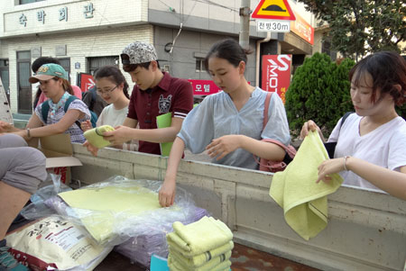 쪽방 주민 사례관리 상담 자원봉사에 참가한 학생들이 대구쪽방상담소에서 가져온 타월과 물티슈를 전해 드리기 좋게 정리하고 있다. 비록 해가 지는 오후 6시였지만 길거리의 열기는 식지 않아 뜨거운 온도를 견뎌가며 작업을 해야 했다. 이화섭 기자
