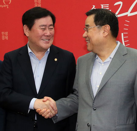 새누리당 김정훈(오른쪽) 정책위의장과 최경환 기획재정부 장관이 27일 국회에서 열린 2016년도 예산안 당정협의에서 마주보며 악수하고 있다. 연합뉴스