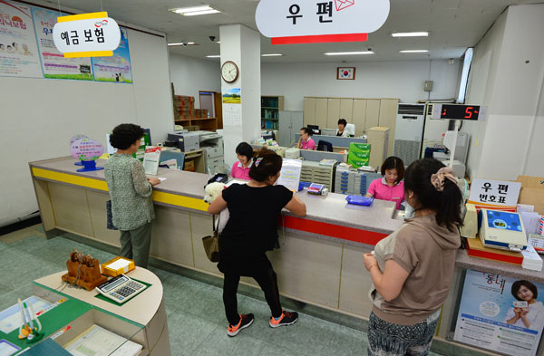 이용률이 저조한 동네 우체국들이 통폐합으로 사라지고 있다. 11월 16일 자로 폐쇄 결정이 내려진 대구 남구 봉덕3동 우체국에서 주민들이 직원들에게 예금과 보험 등 금융 관련 상담을 하고 있다. 정운철 기자 woon@msnet.co.kr