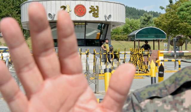 11일 수류탄 폭발사고가 난 육군 50사단 부대 관계자가 부대 입구에서 취재를 막으며 손으로 카메라 렌즈를 가리고 있다. 김영진 기자 kyjmaeil@msnet.co.kr