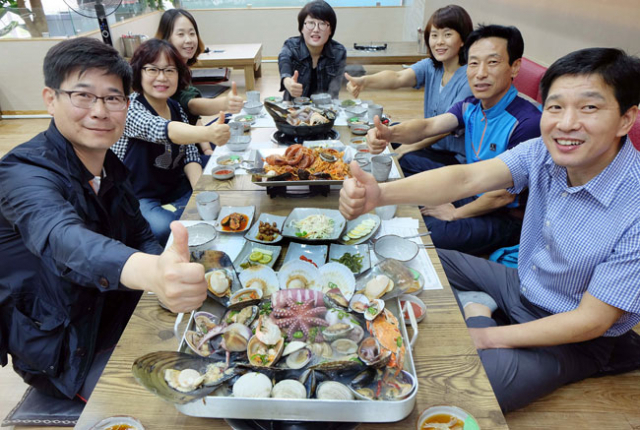 대불 배드민턴 동호회 회원들이 비도생해물탕에서 조개전골, 통문어 해물찜 등 푸짐한 해물 요리를 즐기고 있다. 이들은 