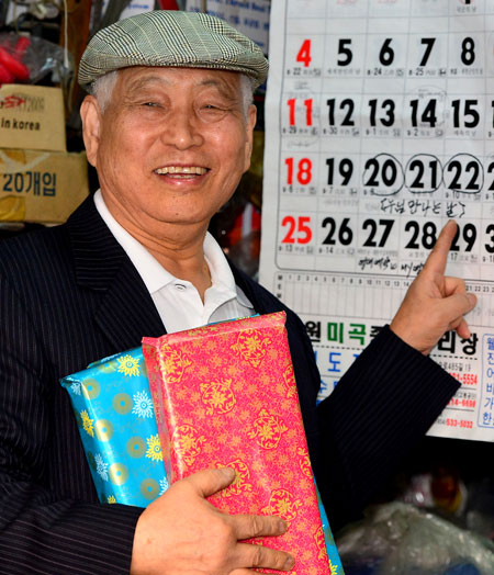 윤희표 씨가 곧 상봉할 누나 금순 씨에게 선물할 내복과 속옷, 화장품 등을 가슴에 안고 달력을 가리키며 환하게 웃고 있다. 정운철 기자 woon@msnet.co.kr