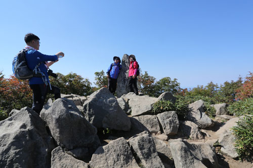 성인봉을 찾은 관광객들이 정상 표지석 앞에서 기념사진을 찍고 있다. 성인봉 정상은 조망권이 확보되지 않아 등산객들에게 큰 아쉬움을 주고 있다. 김도훈 기자 hoon@msnet.co.kr