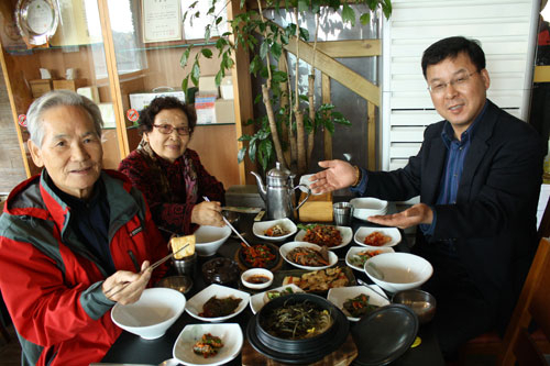대구 팔공산 동화사지구에서 웰스푼 업소로 지정된 한정식 전문점 고향식당의 김남호 대표가 노부부 손님에게 음식을 제공하고 있다.