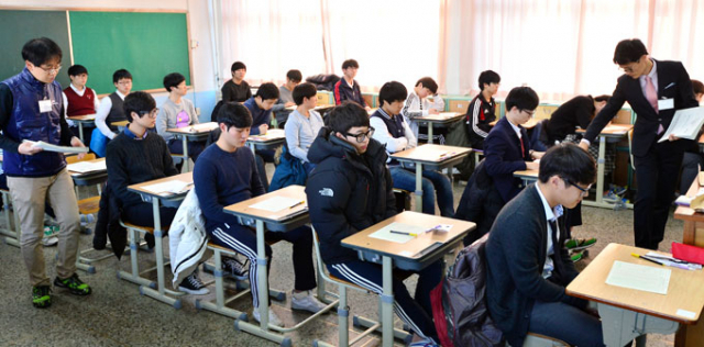2015학년도 대학수학능력시험이 치러진 13일 오전 대구 대륜고등학교 시험장에서 감독관들이 입실한 수험생들에게 1교시 국어영역 문제지를 배부하고 있다. 매일신문 D/B