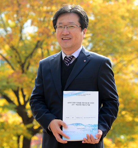 김지훈 교수가 교정에서 자신이 개발한 교수학습 자료집을 들고 기념촬영을 했다. 대구보건대 제공