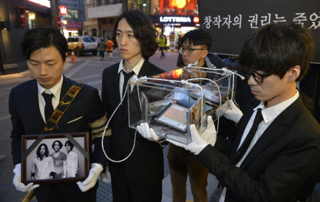 6일 오후 대구 중구 동성로에서 상복을 입은 인디밴드 뮤지션들이 자신들의 영정사진과 앨범이 담긴 관을 들고 행진하고 있다. 찰리키튼, 라이브오, 퍼펫머펫, 오늘도 무사히 등 지역의 인디밴드들은 이날 2