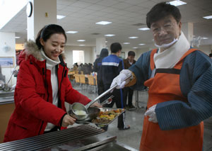 최성해(오른쪽) 총장이 홍수희 씨에게 떡국을 퍼주며 