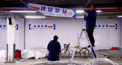 설 대목을 앞두고 화재로 점포를 잃은 팔달신시장 상인들이 18일 오후 시장 내 공영주차장에 임시점포를 마련하고 장사 준비를 하고 있다. 김영진 기자 kyjmaeil@msnet.co.kr