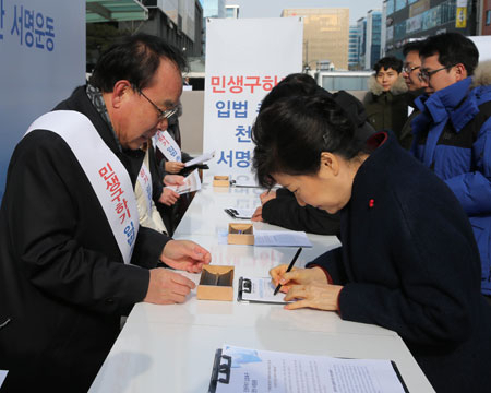 박근혜 대통령이 18일 경기도 성남시 판교테크노밸리 판교역 광장에 있는 민생구하기 입법촉구 천만서명운동본부부스를 찾아 경제활성화법 처리를 촉구하는 서명을 하고 있다. 연합뉴스