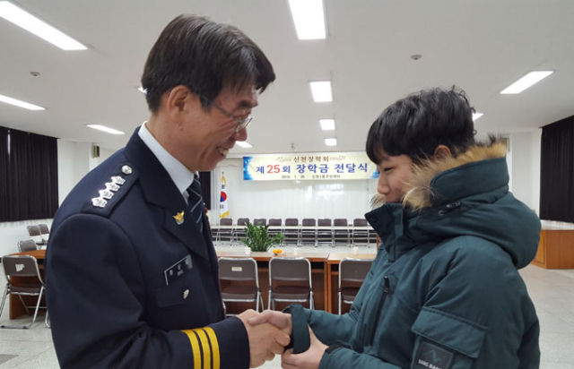 신천장학회 회원 류상열 총경이 한 학생에게 장학금을 전달하며 격려하고 있다. 대구경찰청 제공