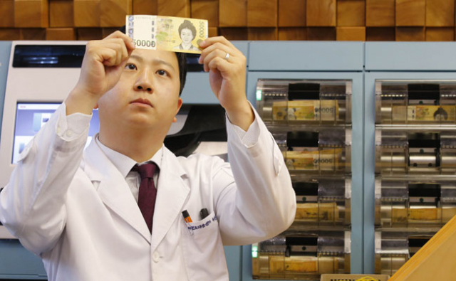 지난해 5만원권 위조지폐가 45% 늘어나 전체 위폐의 67%를 차지한 것으로 나타났다. KEB하나은행 위변조대응센터에서 직원이 위폐 감식을 하고 있다. 연합뉴스