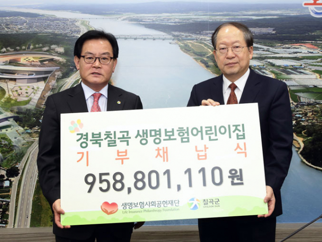 (재)생명보험사회공헌재단 유석쟁(오른쪽) 전무가 백선기 칠곡군수에게 군립지천어린이집을 기부채납한다는 내용을 담은 패널을 전달하고 있다. 칠곡군 제공