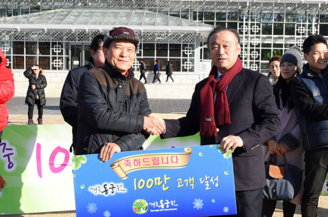 최양식(오른쪽) 경주시장이 경주 동경원 100만 번째 관람객 윤무연 씨에게 기념품을 전달하고 있다. 경주시 제공