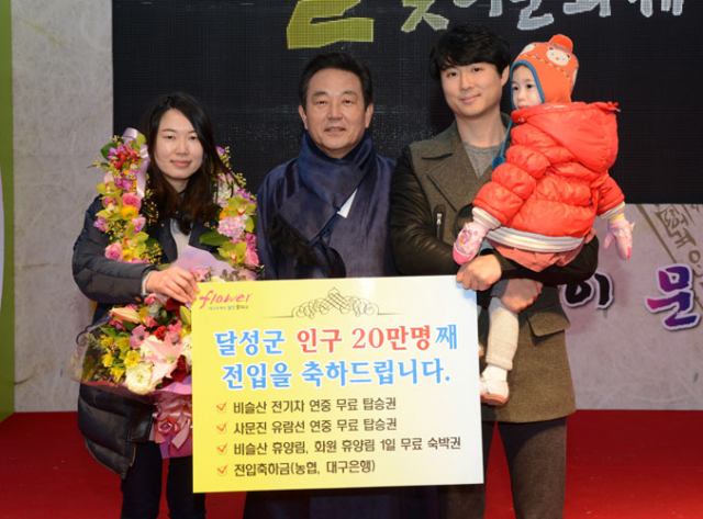 김문오 달성군수가 20만 명째 달성군민으로 전입해온 김태수(39) 씨 가족에게 축하 선물을 전달했다. 달성군 제공
