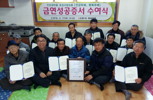 영주시보건소로부터 금연성공증서와 기념품을 전달받은 백곡마을 주민들이 기뻐하고 있다. 영주시 제공