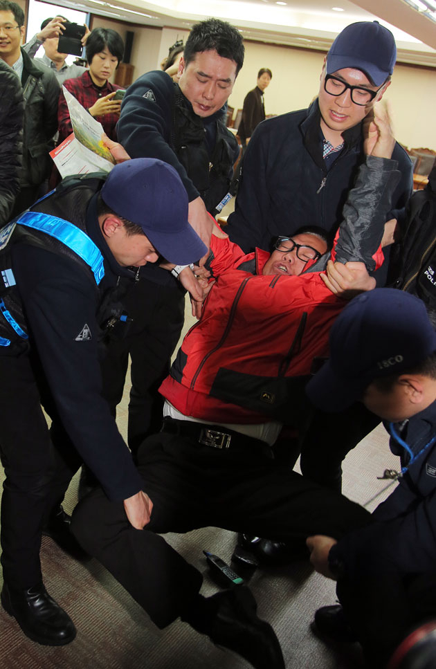 새누리당 서울 종로에 출마한 한 예비후보가 6일 오전 서울 여의도 당사에서 공천배제에 항의하며 이한구 공천관리위원장 면담을 요청하다 경찰에 체포되고 있다. 연합뉴스