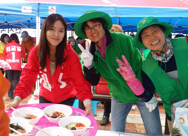 영주소백산마라톤대회에서 새마을부녀회원들과 함께 국수 도우미로 나선 최교일 새누리당 후보의 딸 최윤지(24) 씨가 환하게 웃고 있다. 고도현 기자