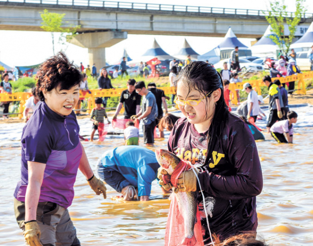 의성 세계연축제장에서 한 여학생이 메기, 송어 맨손잡기 체험을 즐기고 있다.
