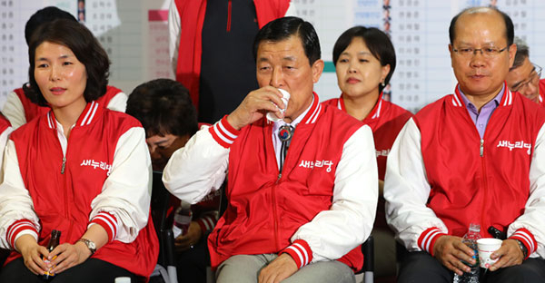 새누리당 황진하 사무총장이 13일 밤 서울 여의도 당사에서 각 방송사의 선거 개표 방송을 바라보며 속이 타는 듯 물을 마시고 있다. 연합뉴스
