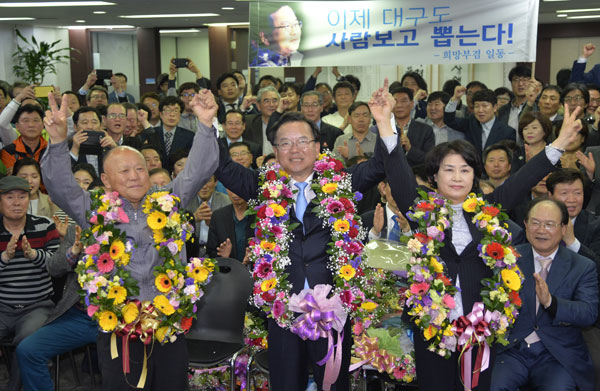 대구 수성갑에 출마한 더불어민주당 김부겸(가운데) 당선자가 13일 밤 당선이 확실시되자 자신의 선거사무소에서 부친과 부인 이유미 씨와 함께 꽃다발을 목에 걸고 환호하고 있다. 우태욱 기자 woo@msnet.co.kr