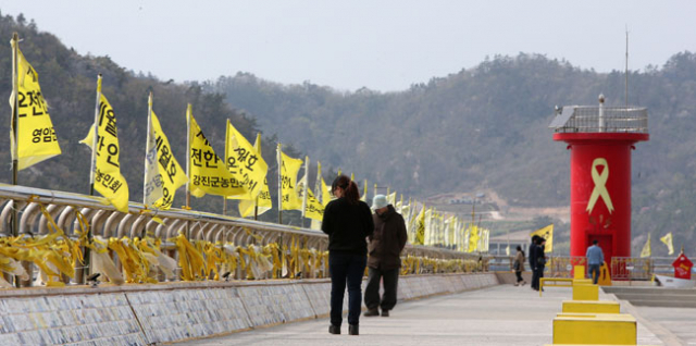 세월호 참사가 16일 2주기를 맞는다. 9명의 미수습자가 가족 곁으로 돌아오지 못했고, 사고 해역에서는 선체 인양을 위한 준비 작업이 진행되고 있다. 사진은 12일 전남 진도 팽목항의 방파제를 찾은 추모객의 모습. 2016.4./연합뉴스