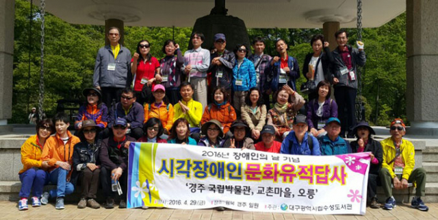 경주 문화유적 답사 여행에 참가한 시각장애인들과 자원봉사자들이 경주국립박물관 선덕여왕신종 앞에서 기념촬영을 하고 있다.