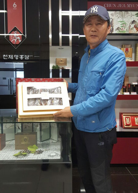 박관식 풍기특산물영농조합법인 대표가 풍기인삼을 활용해 만든 기능성 건강식품을 자랑스레 들어 보이고 있다.