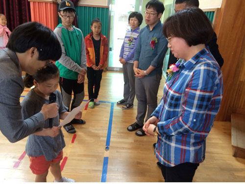 지난 13일 금성초교에서 열린 스승의 날 행사에 학생이 교사에게 감사의 마음을 담은 상장을 수여하며 낭독하고 있다. 금성초교 제공