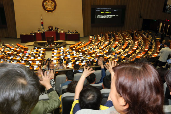 세월호 희생자 가족들이 19일 오전 국회 본회의장에서 열린 제19대 국회 마지막 본회의를 방청하던 중 더불어민주당 의원들의 손 인사에 손을 흔들며 답례하고 있다. 이날 본회의에는 