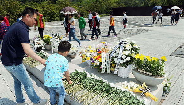 고(故) 노무현 전 대통령 서거 7주기를 하루 앞둔 22일 경남 김해시 진영읍 본산리 봉하마을에서 참배객들이 묘역에 헌화하고 있다. 연합뉴스