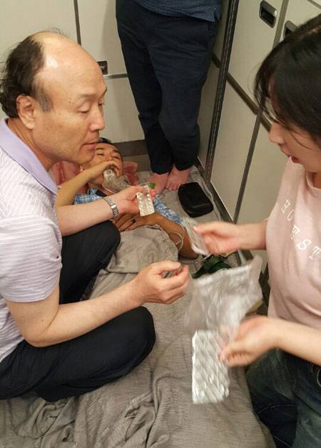 메디시티대구 해외의료봉사단 단원들이 항공기 내에서 갑자기 협심증 의심 증상을 보인 환자를 비행기 뒤편 공간으로 옮겨 응급치료를 하고 있다. 대구시의사회 제공