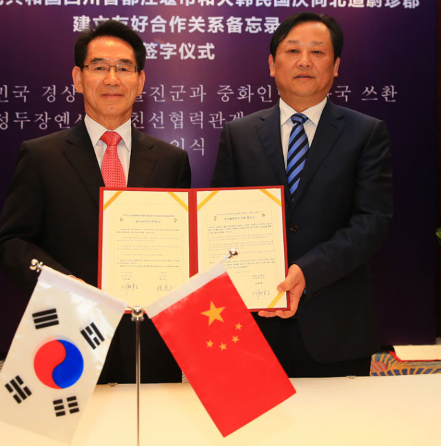 임광원(왼쪽) 울진군수와 중국 쓰촨성 두장옌시 허에이카이 시장이 양 도시 간의 우호교류를 약속하는 협약서에 서명한 후 기념촬영을 하고 있다. 울진군 제공