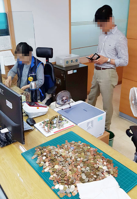 27일 오전 대구 북구 침산동 국민건강보험공단 관계자들이 민원인이 가져 온 동전을 세고 있다.