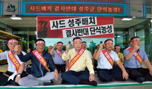 12일 사드 배치 지역이 성주군으로 결정된 것으로 전해지자 김항곤(앞줄 가운데) 성주군수와 군의원들이 군청 현관 앞에서 단식농성을 벌이고 있다. 우태욱 기자 woo@msnet.co.kr