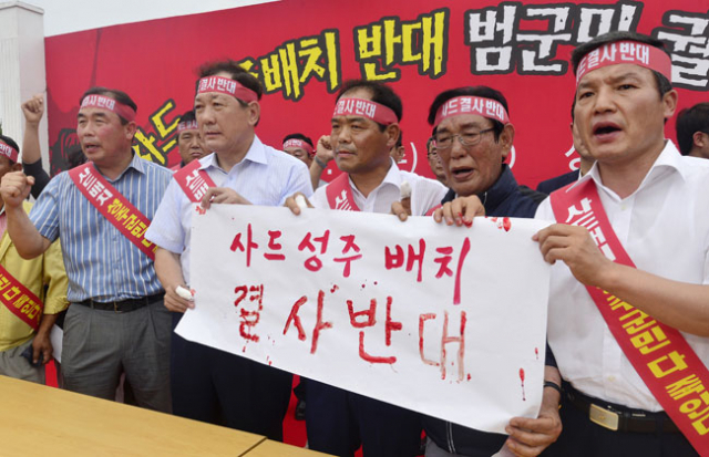 13일 성주군 성주읍 성밖숲에서 열린 사드 배치 반대 범군민궐기대회에서 김항곤(왼쪽에서 두 번째) 성주군수를 비롯한 참가 대표자들이 사드 반대 혈서를 쓴 뒤 들어 보이고 있다. 성일권 기자 sungig@msnet.co.kr