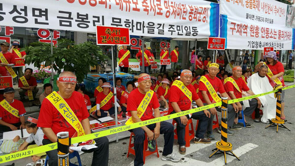 봉화 물야면 가평리 주민들이 지난 17일 열린 집회에서 머리를 삭발하고 있다. 마경대 기자