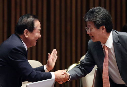 새누리당 서청원(왼쪽) 의원이 20일 오전 국회 본회의장에서 열린 사드 관련 긴급현안 질문에 참석, 자신의 자리로 찾아온 유승민 의원과 악수하고 있다. 연합뉴스