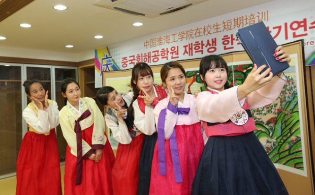영진전문대 단기 연수 프로그램에 참가한 중국 강소성 회해공학원 2, 3학년생들이 한복 입기 체험을 하면서 셀카를 찍고 있다.(사진 위) 중국 청도 밍런호텔에서 실습중인 영진전문대 학생들. 영진전문대 제공