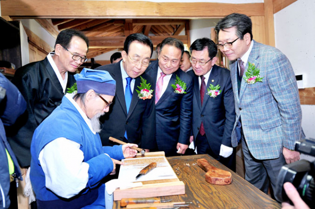 군위읍 서부리 삼국유사 목판복원사업 현장을 찾은 김관용 경북지사와 김영만 군수 일행.