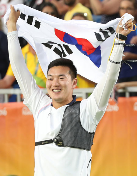 7일 리우올림픽 남자 양궁 단체전에서 금메달을 획득한 구본찬이 태극기를 펼쳐들며 관중의 환호에 답하고 있다. 연합뉴스