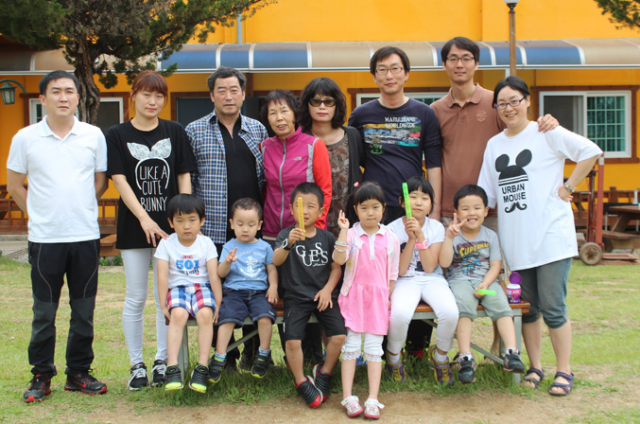 홍갑순 씨(뒷줄 왼쪽에서 네 번째)와 가족들이 여행지에서 기념촬영을 하고 있다.