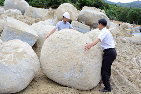 달성군 관계자가 유가면 용리 비슬산유스호스텔 건립 현장에서 발견된 용의 알 모양 돌의 크기를 재고 있다. 달성군 제공